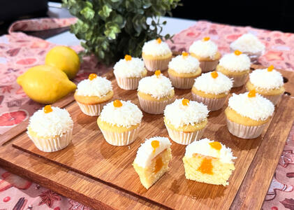 Lemon cupcakes filled with mango puree and topped with coconut ganache